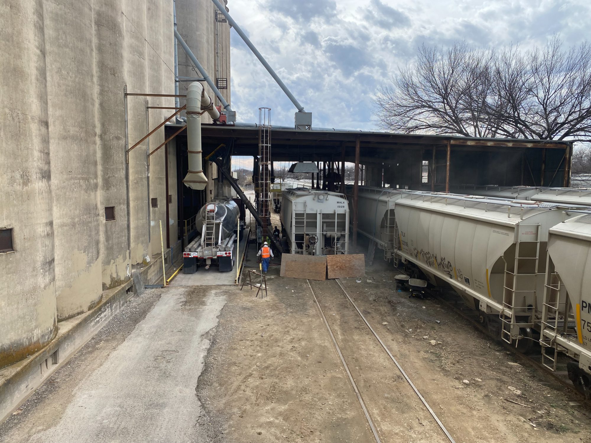 Pneumatic trailer loading beside rail cars